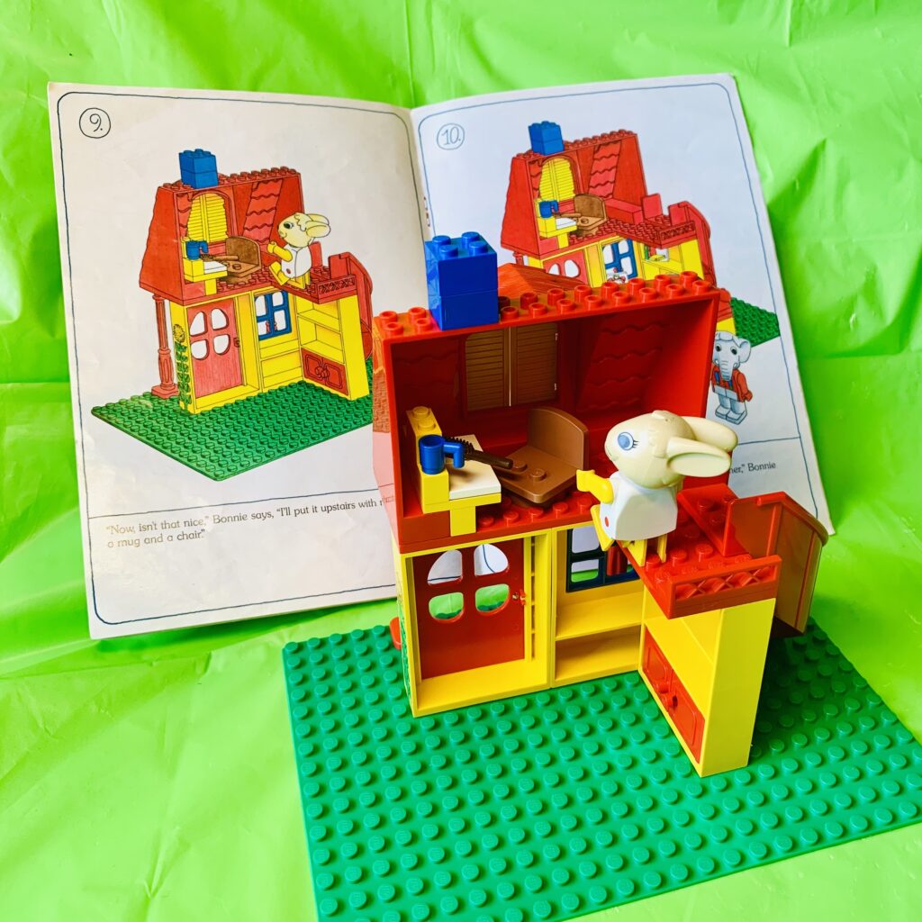 Instruction manual showing how to build the upstairs, with LEGO model in foreground.