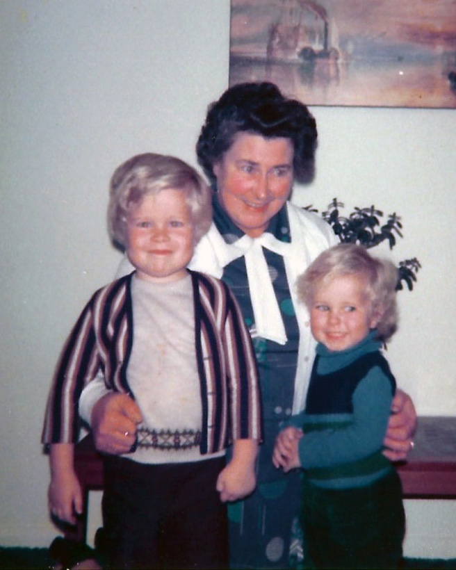 Polaroid of a dark haired women, cuddling two young blonde boys.