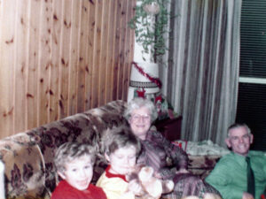 Polaroid of a two elderly friends and two young boys relaxing on a couch.