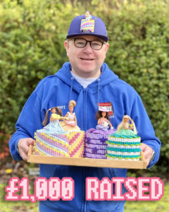 Stewart standing outside holding a tray with 4 different Lego toilet dolls on it and Â£1,000.