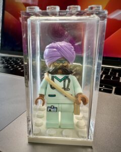 Surgeon minifigure with pale green scrubs, stethoscope and purple turban.